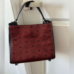 Authentic MCM bag with top handle and strap.